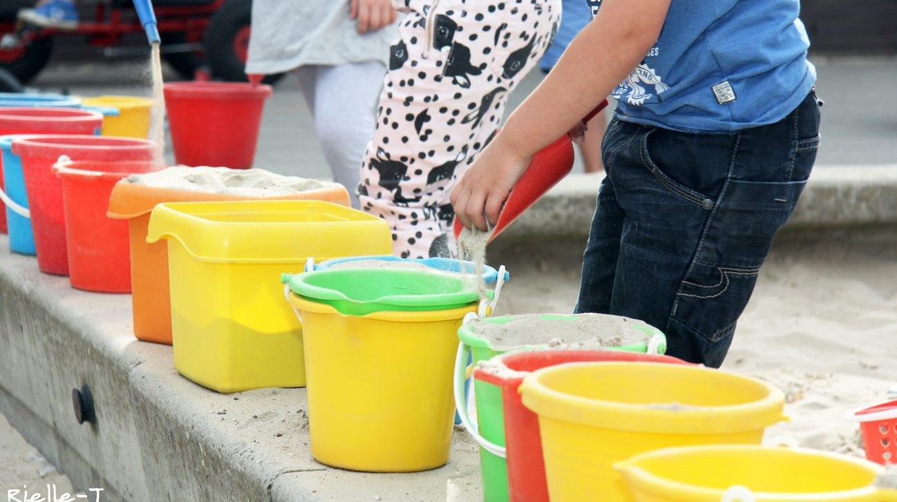 Kinderen spelen met kleurige emmers in de zandbak op het schoolplein van Talent - Jan Ligthartschool Driecant in Tilburg. Kinderen spelen met kleurige emmers in de zandbak op het schoolplein van Talent - Jan Ligthartschool Driecant in Tilburg.