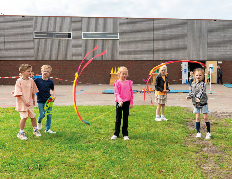 Kinderen spelen met kleurige ribbonsticks op het schoolplein van IKC de Driemaster in Hoek van Holland. Kinderen spelen met kleurige ribbonsticks op het schoolplein van IKC de Driemaster in Hoek van Holland.