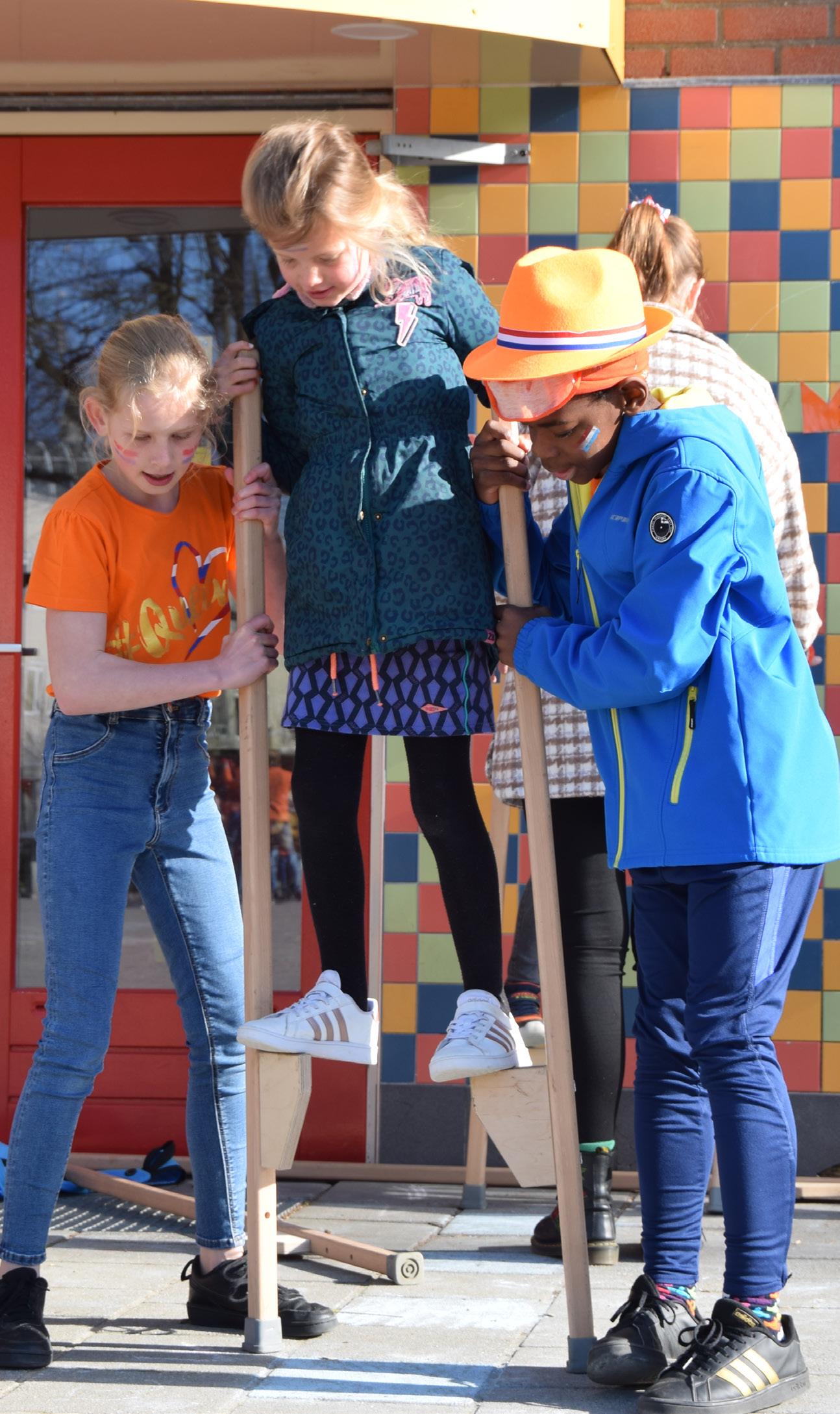 Kinderen spelen met stelten op het schoolplein van de Paasbergschool in Ede.