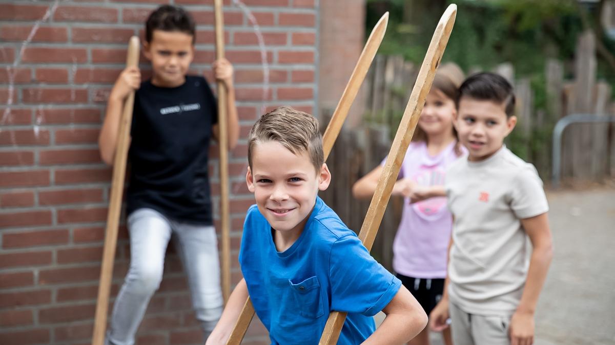 Kinderen spelen met stokken op het schoolplein van Rooms Katholieke Basisschool De Schakel in Apeldoorn. Kinderen spelen met stokken op het schoolplein van Rooms Katholieke Basisschool De Schakel in Apeldoorn.