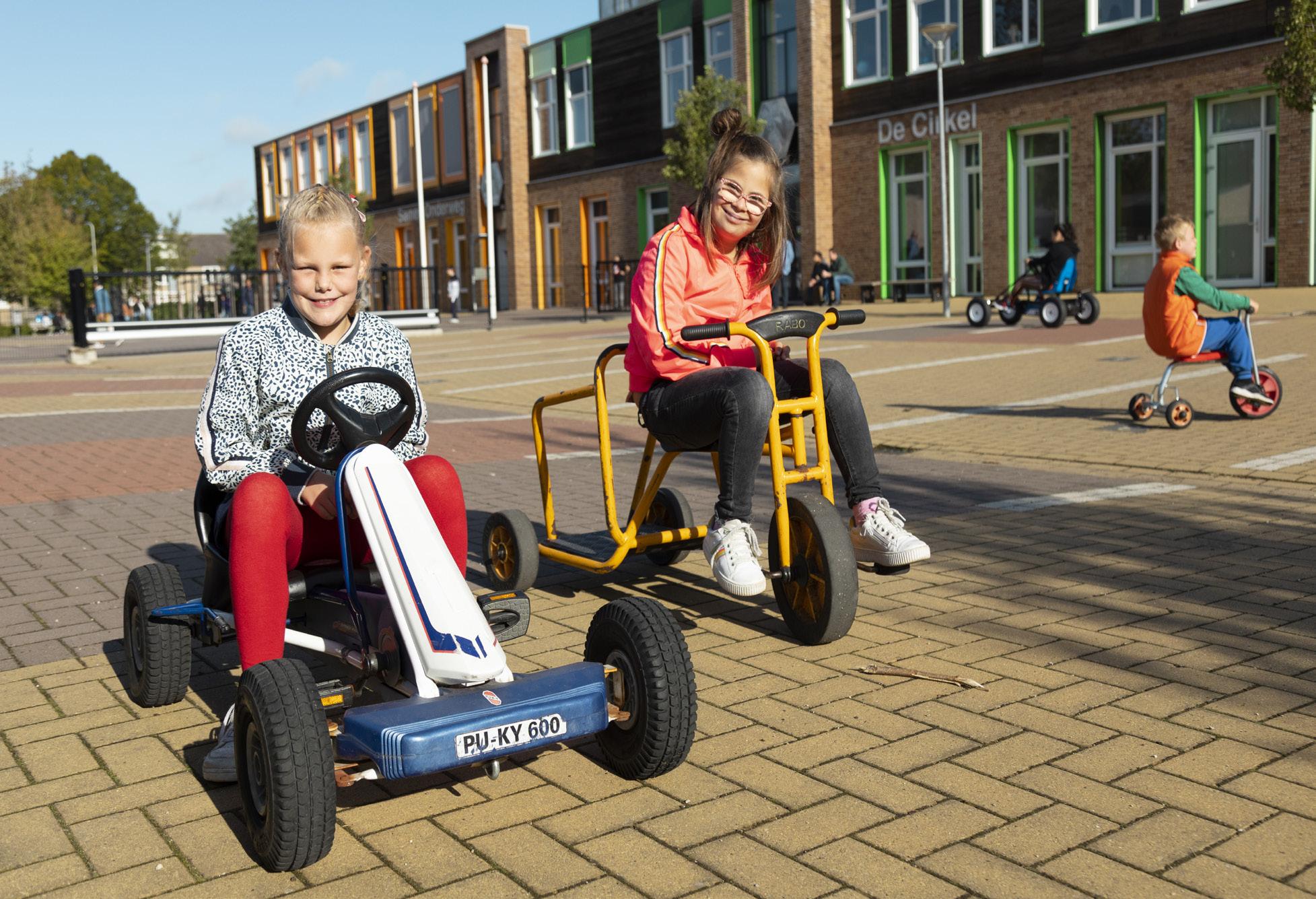 Kinderen spelen met voertuigen op het schoolplein van De Cirkel Christelijk Onderwijs ZML in Gorinchem.
