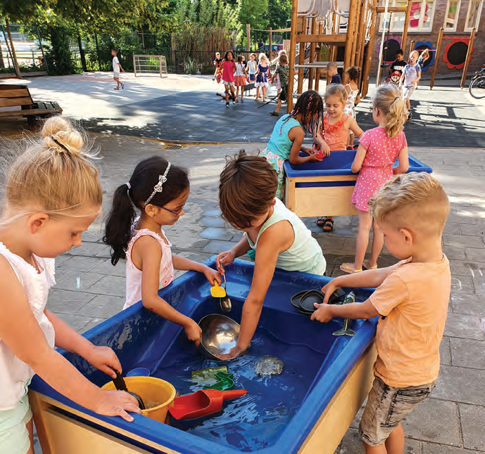 Kinderen spelen met water en speelgoed op het schoolplein van De Vlierboom in Den Haag. Kinderen spelen met water en speelgoed op het schoolplein van De Vlierboom in Den Haag.