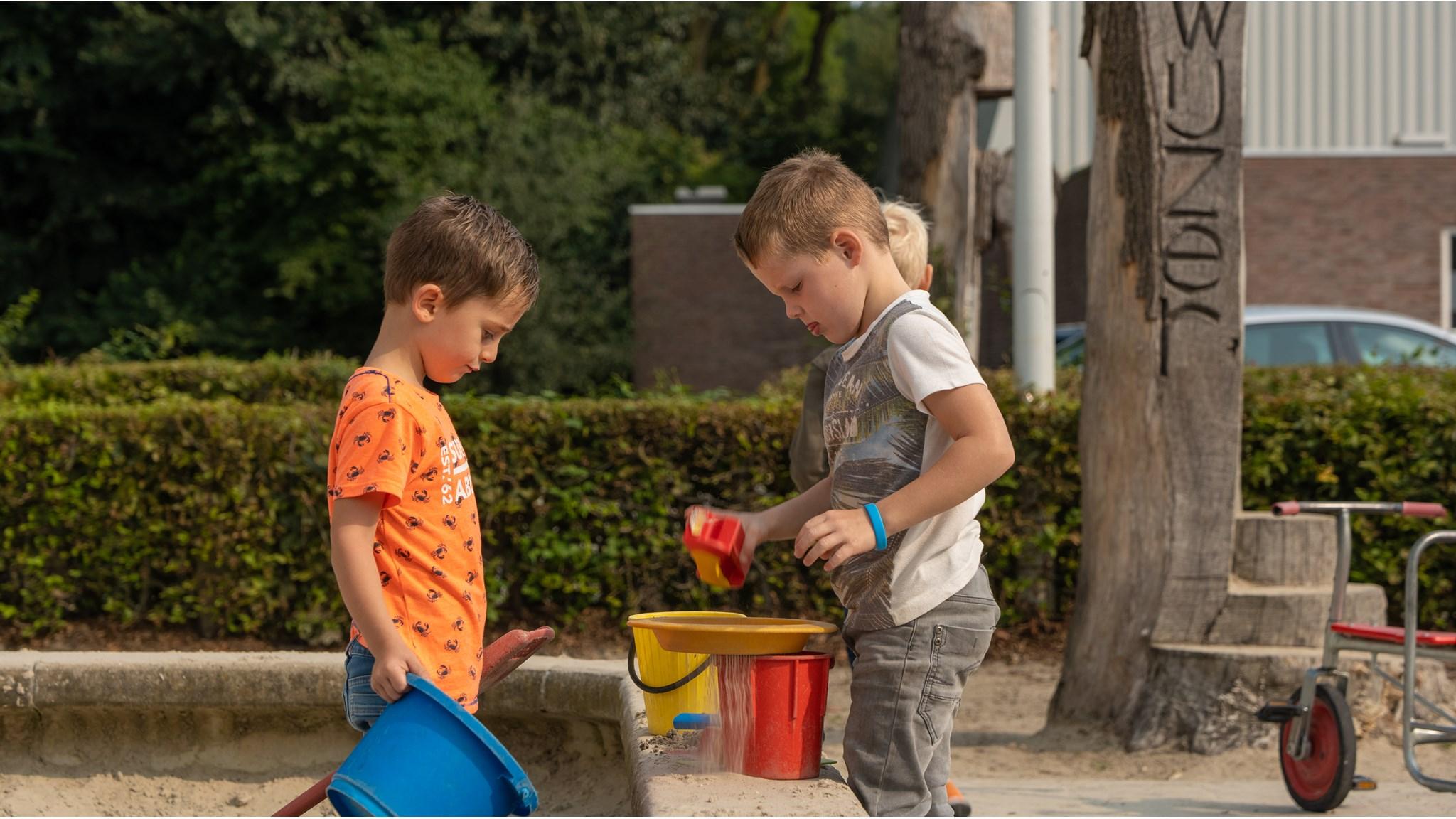 Kinderen spelen met zand en speelgoed in de zandbak op het schoolplein van De Zonnewijzer in Dronten. Kinderen spelen met zand en speelgoed in de zandbak op het schoolplein van De Zonnewijzer in Dronten.