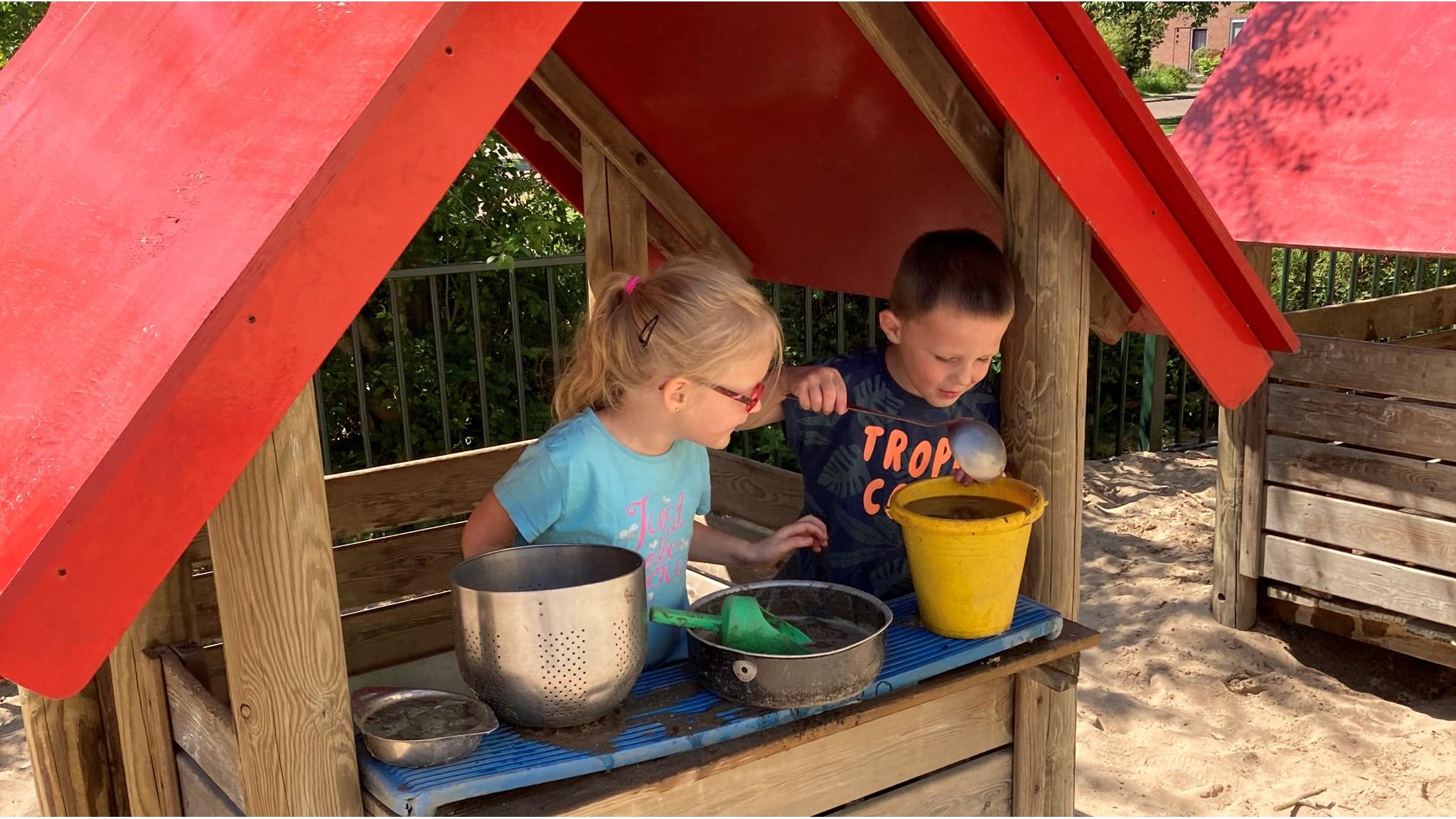 Kinderen spelen met zand en water op het schoolplein van Protestants Christelijke Basisschool De Rank in Toldijk. Kinderen spelen met zand en water op het schoolplein van Protestants Christelijke Basisschool De Rank in Toldijk.