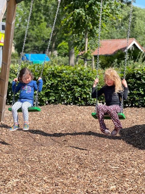 Kinderen spelen op de schommels op het schoolplein van OBS Dirk van Dijk in Kampen.