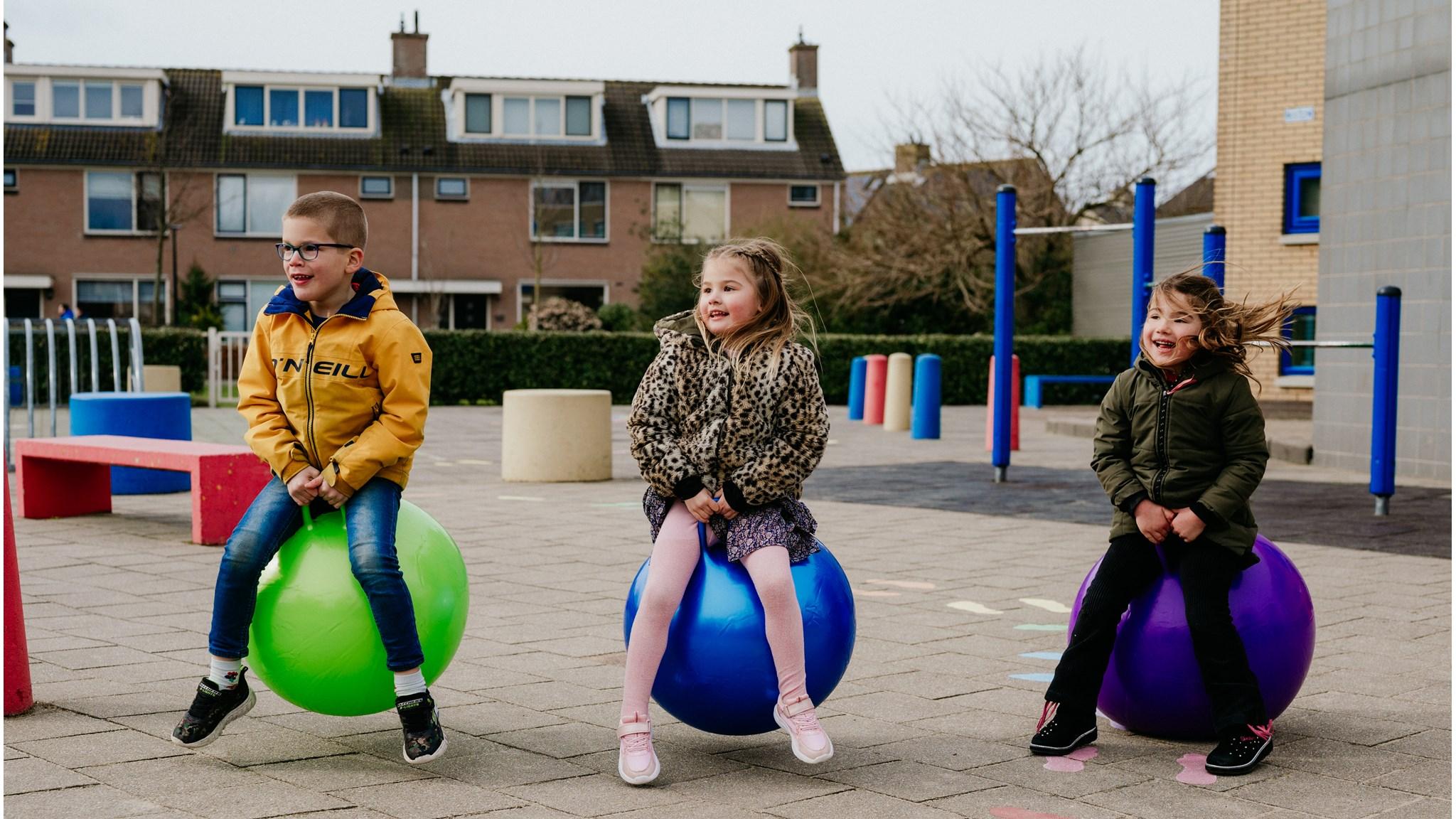 Kinderen spelen op grote ballen op het schoolplein van WereldWijs in Noordwijk (Zuid-Holland). Kinderen spelen op grote ballen op het schoolplein van WereldWijs in Noordwijk (Zuid-Holland).