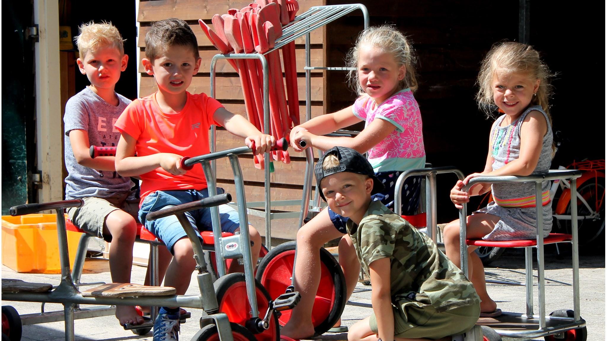 Kinderen spelen op het schoolplein van Basisschool Anne de Vries in Epe met stalen speelgoedfietsen. Kinderen spelen op het schoolplein van Basisschool Anne de Vries in Epe met stalen speelgoedfietsen.