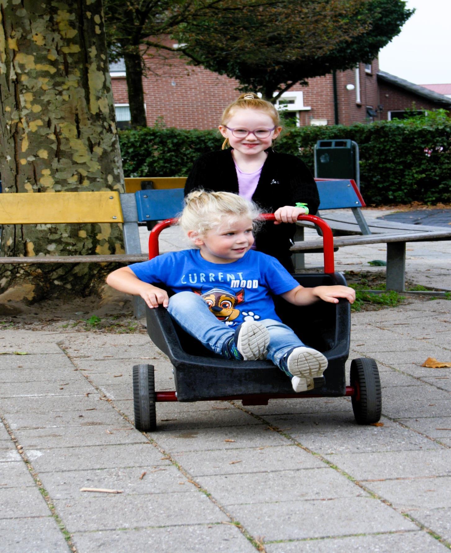 Kinderen spelen op het schoolplein van Basisschool Jan Ligthart in Zelhem met een kruiwagen.