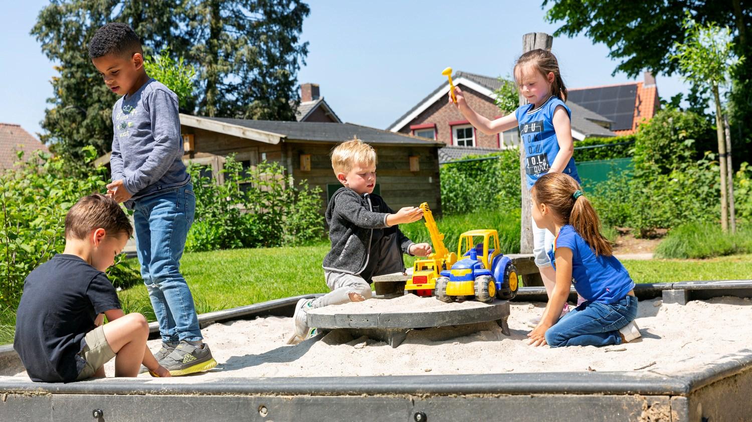Kinderen spelen op het schoolplein van Basisschool Sint Anna in Blitterswijck met zand en speelgoedtrucks. Kinderen spelen op het schoolplein van Basisschool Sint Anna in Blitterswijck met zand en speelgoedtrucks.