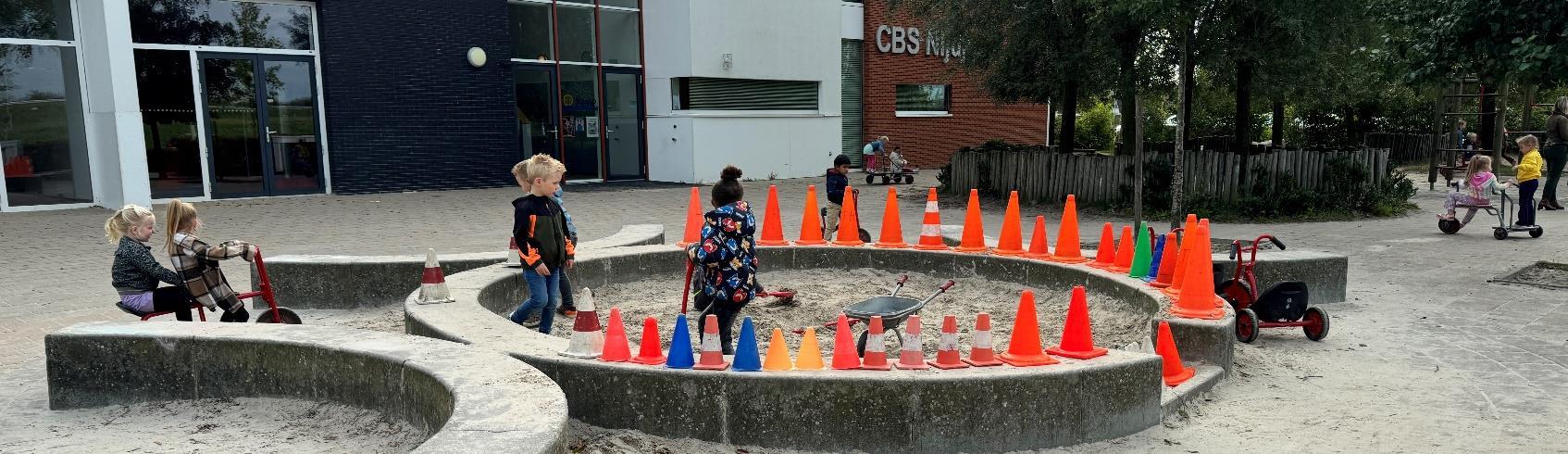 Kinderen spelen op het schoolplein van CBS Nijdjip in Grou, met verkeersconussen in het zand. Kinderen spelen op het schoolplein van CBS Nijdjip in Grou, met verkeersconussen in het zand.