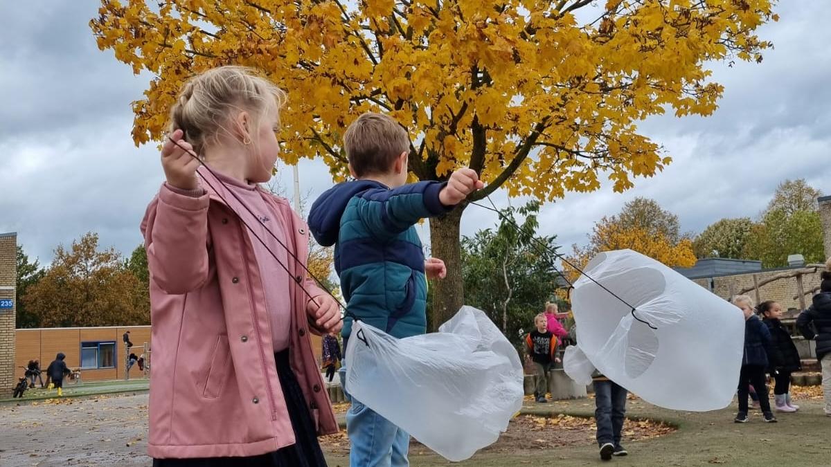 Kinderen spelen op het schoolplein van De Buizerd in Wijchen met zelfgemaakte luchtballonnen onder een boom in de herfst. Kinderen spelen op het schoolplein van De Buizerd in Wijchen met zelfgemaakte luchtballonnen onder een boom in de herfst.