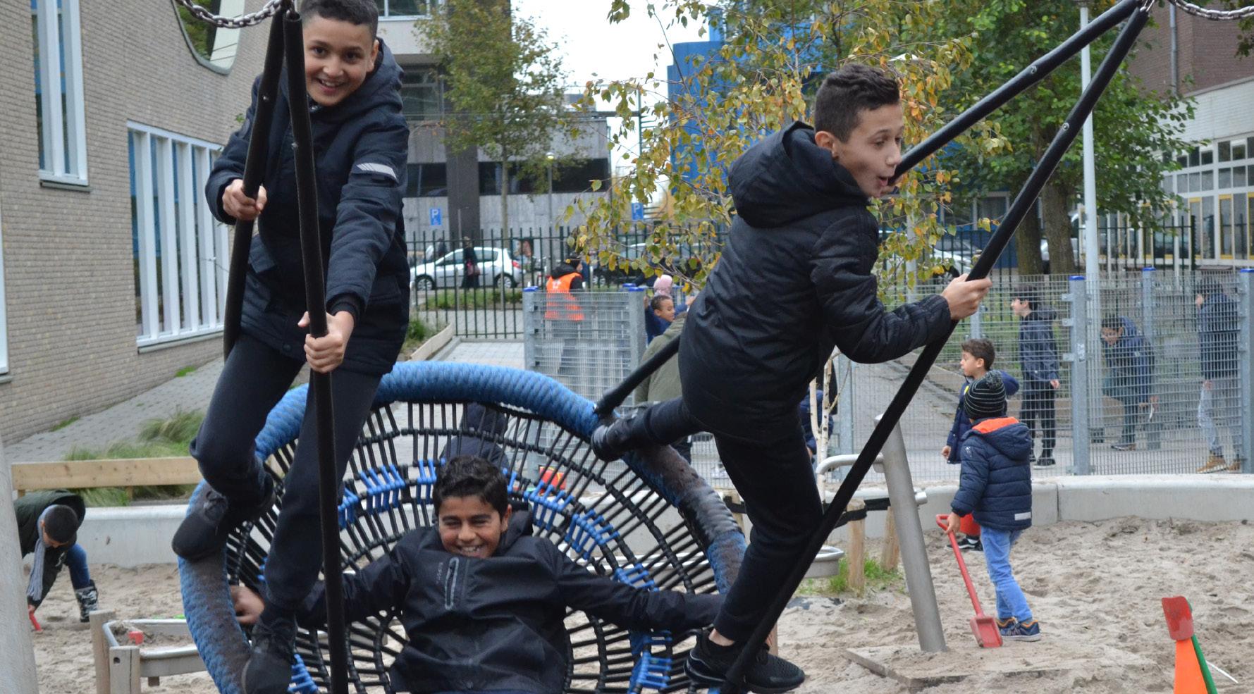 Kinderen spelen op het schoolplein van de Burgemeester De Vlugtschool in Amsterdam. Kinderen spelen op het schoolplein van de Burgemeester De Vlugtschool in Amsterdam.