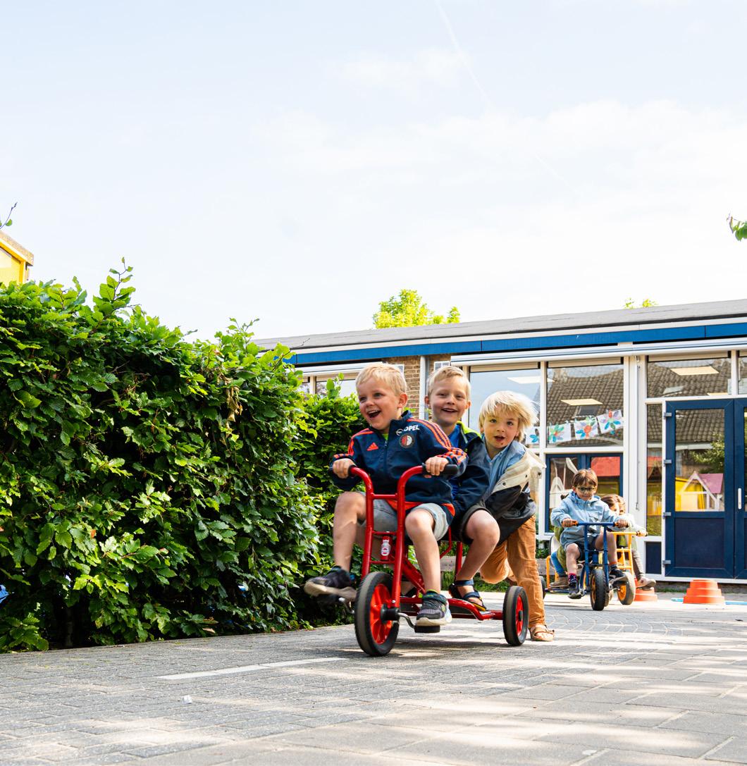 Kinderen spelen op het schoolplein van de Fatimaschool in Rotterdam met loopfietsen. Kinderen spelen op het schoolplein van de Fatimaschool in Rotterdam met loopfietsen.