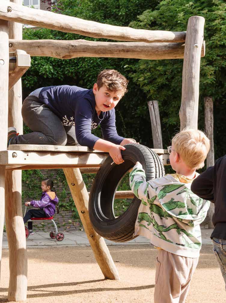 Kinderen spelen op het schoolplein van de Jan Ligthartschool in Arnhem met een autoband en een speeltoestel. Kinderen spelen op het schoolplein van de Jan Ligthartschool in Arnhem met een autoband en een speeltoestel.