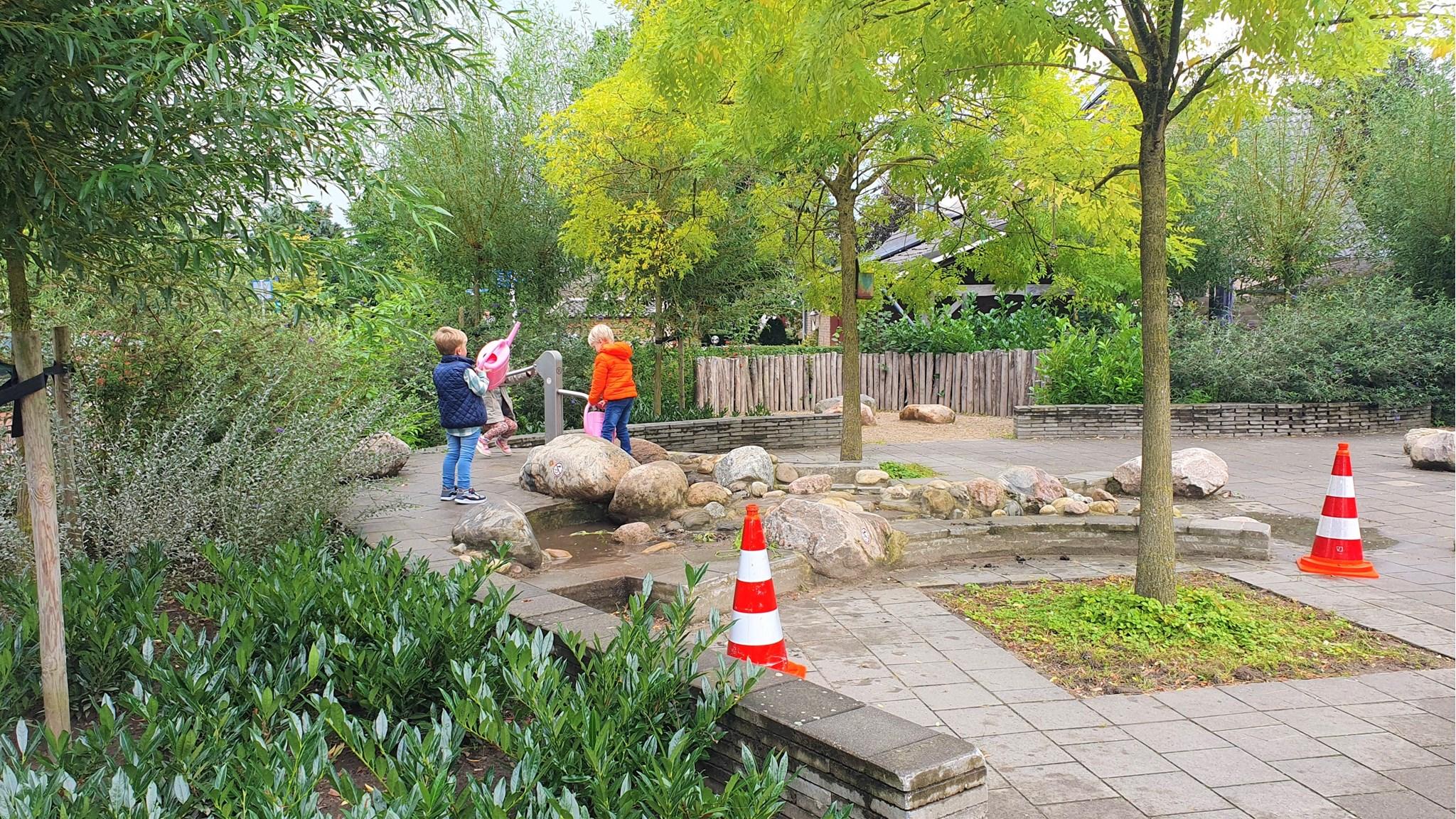 Kinderen spelen op het schoolplein van IKC De Stek in Est, omringd door natuur en stenen. Kinderen spelen op het schoolplein van IKC De Stek in Est, omringd door natuur en stenen.