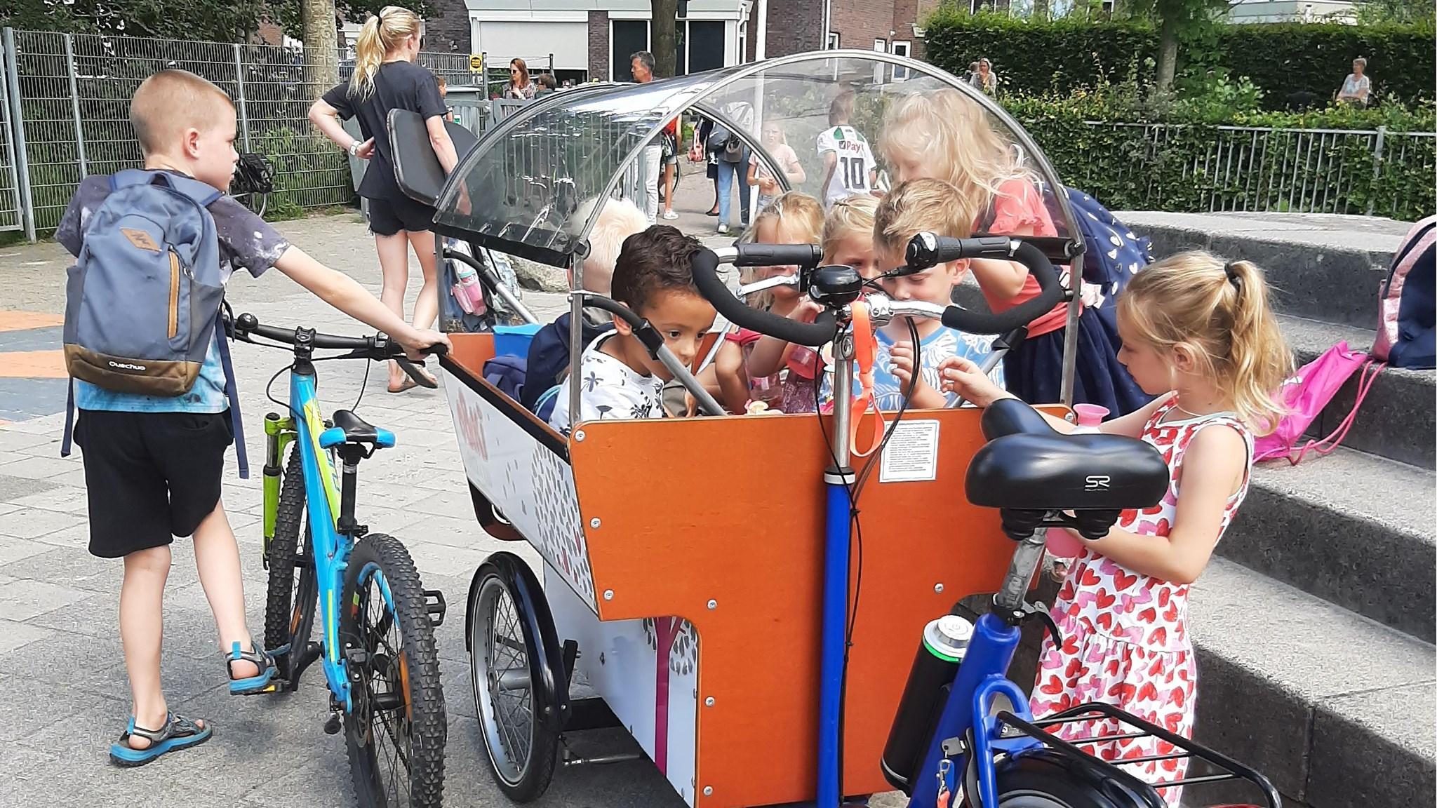 Kinderen spelen op het schoolplein van obs Gieten in Gieten met een speciale fiets voor kinderactiviteiten. Kinderen spelen op het schoolplein van obs Gieten in Gieten met een speciale fiets voor kinderactiviteiten.