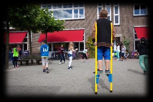 Kinderen spelen op het schoolplein van Sint Bernardusschool in Haarlem, met een jongen op stelten in het midden van de activiteit. Kinderen spelen op het schoolplein van Sint Bernardusschool in Haarlem, met een jongen op stelten in het midden van de activiteit.