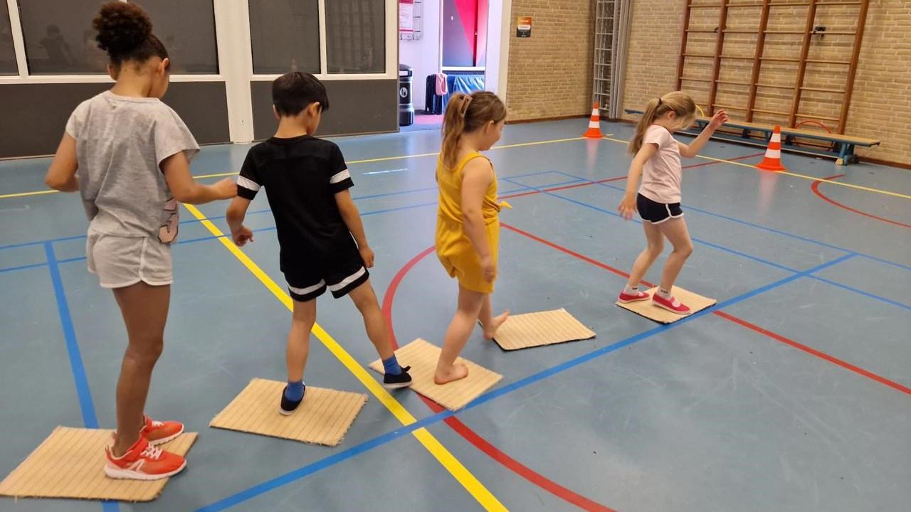 Kinderen spelen op kartonnen vloerpanelen in de gymzaal van obs Willem Wilmink in Enschede. Kinderen spelen op kartonnen vloerpanelen in de gymzaal van obs Willem Wilmink in Enschede.