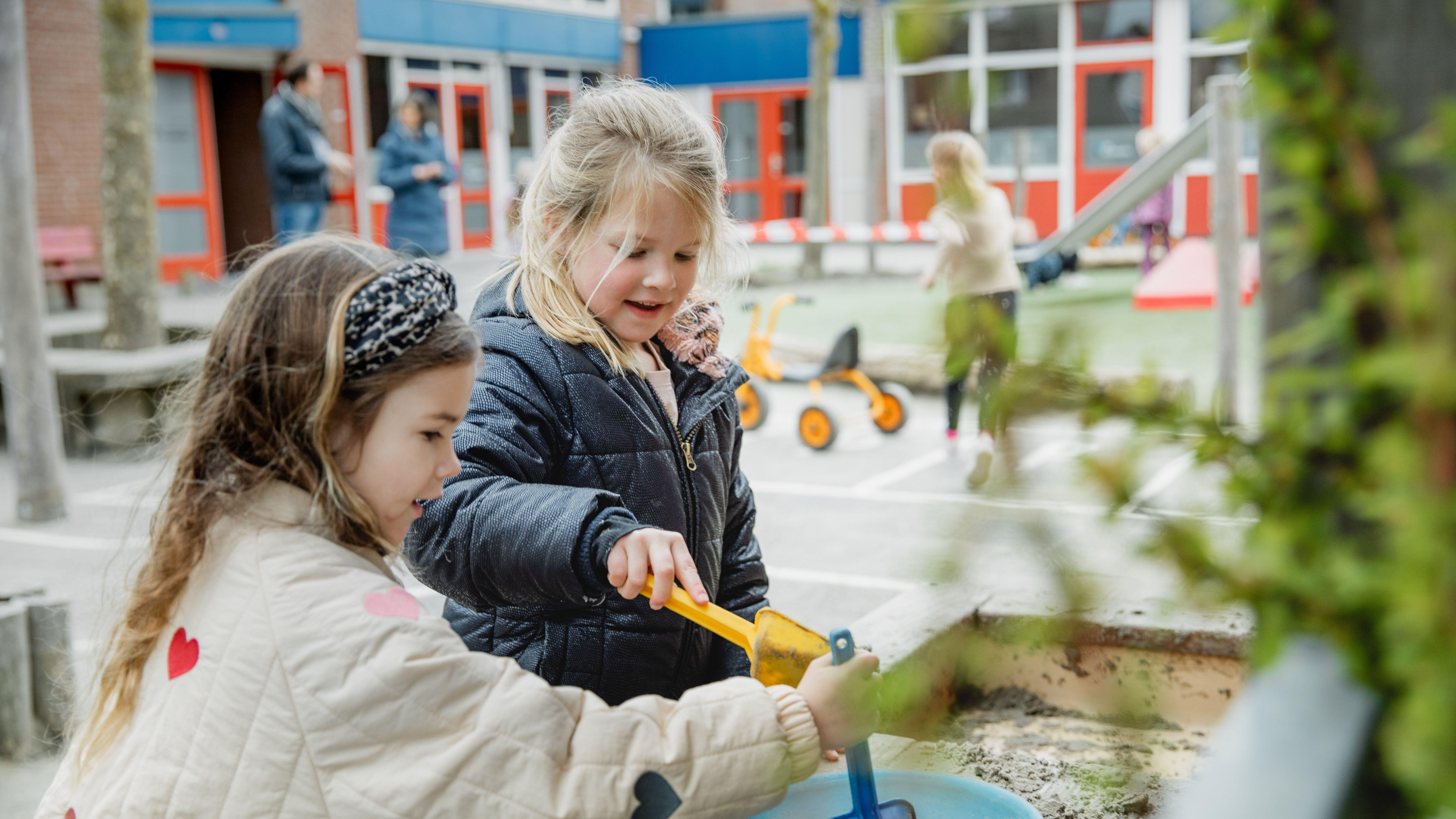 Kinderen spelen samen met zand en speelgoed op het schoolplein van Openbare Basisschool De Lisdodde in Emmen. Kinderen spelen samen met zand en speelgoed op het schoolplein van Openbare Basisschool De Lisdodde in Emmen.