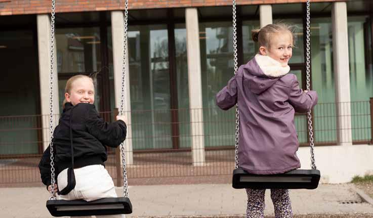Kinderen spelen samen op de schommels op het schoolplein van Het Avontuur in Hoef en Haag.