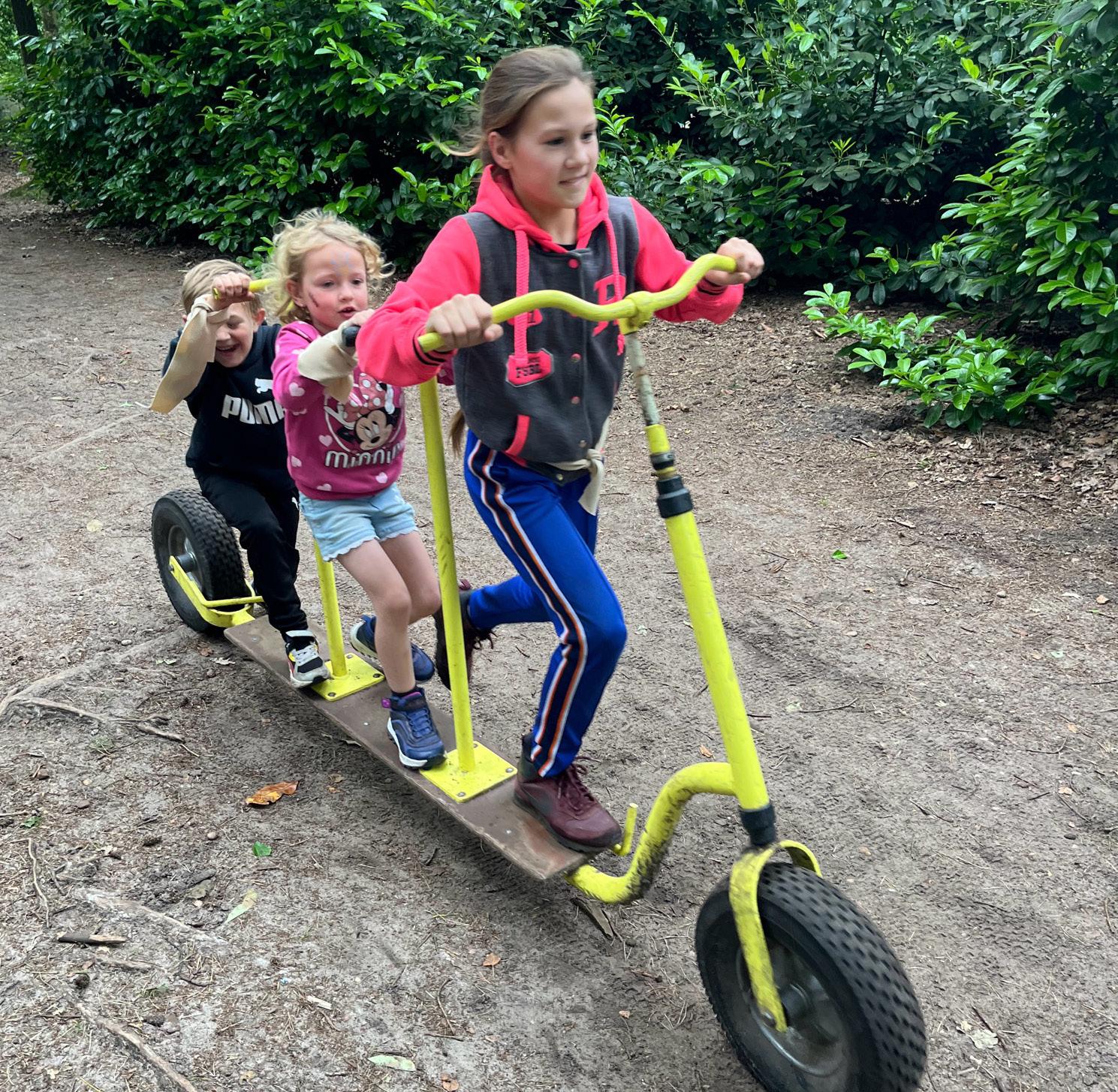 Kinderen spelen samen op een gele driewieler op het schoolplein van St. Jozefschool in Achterveld (Utrecht). Kinderen spelen samen op een gele driewieler op het schoolplein van St. Jozefschool in Achterveld (Utrecht).