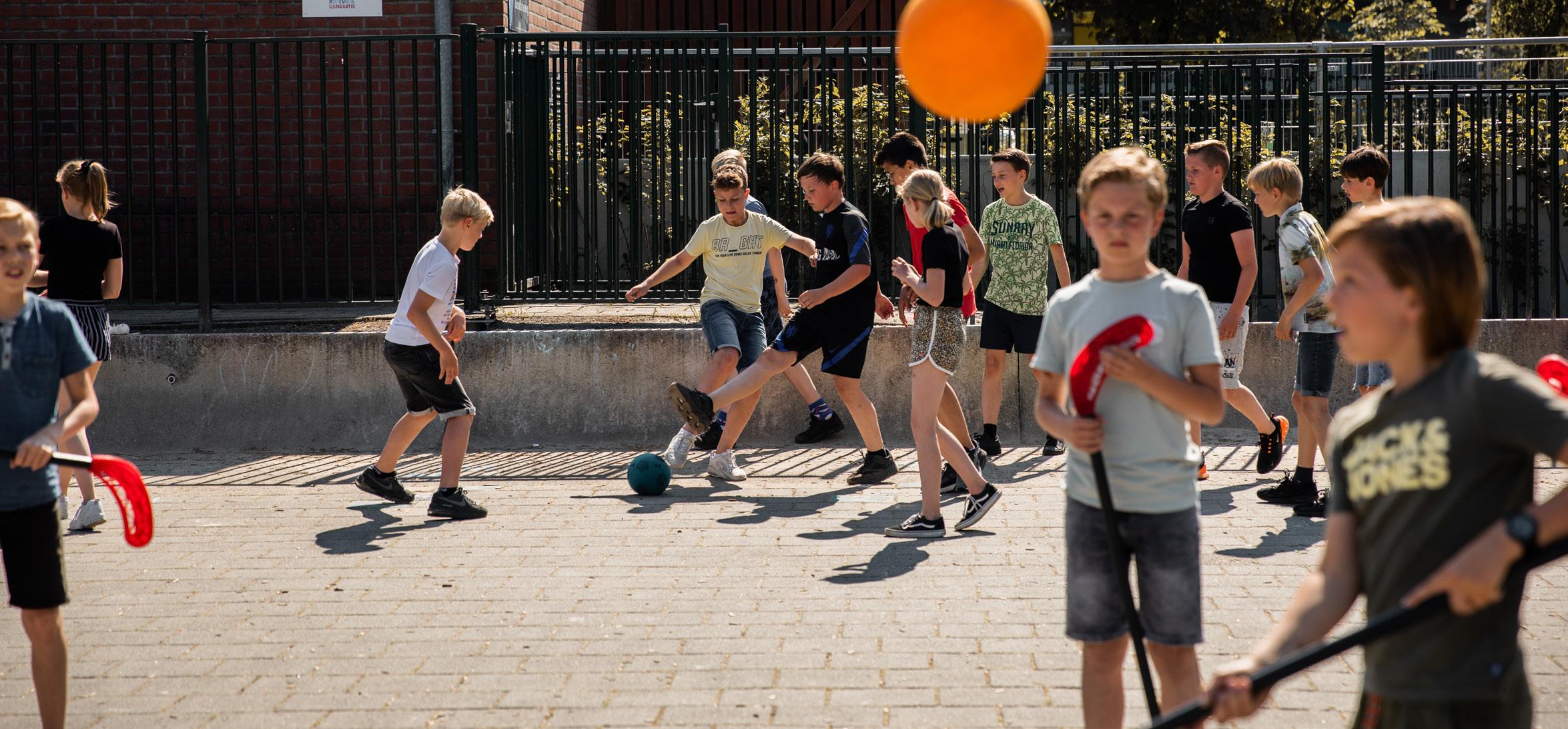 Kinderen spelen samen op het schoolplein van Paasbergschool in Ede.