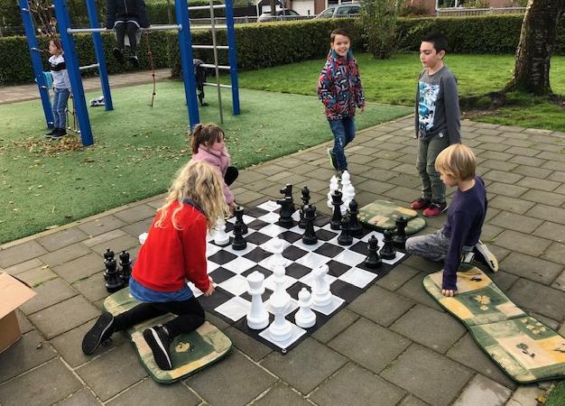 Kinderen spelen schaken op het schoolplein van Openbare Basisschool De Klimop in Dreischor. Kinderen spelen schaken op het schoolplein van Openbare Basisschool De Klimop in Dreischor.