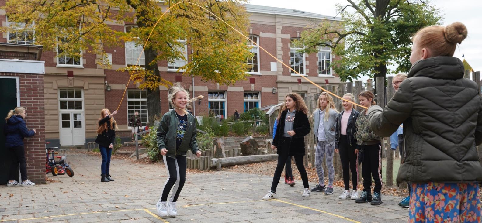 Kinderen spelen touwtje springen op het schoolplein van Openbare Basisschool De Kring in Haarlem. Kinderen spelen touwtje springen op het schoolplein van Openbare Basisschool De Kring in Haarlem.