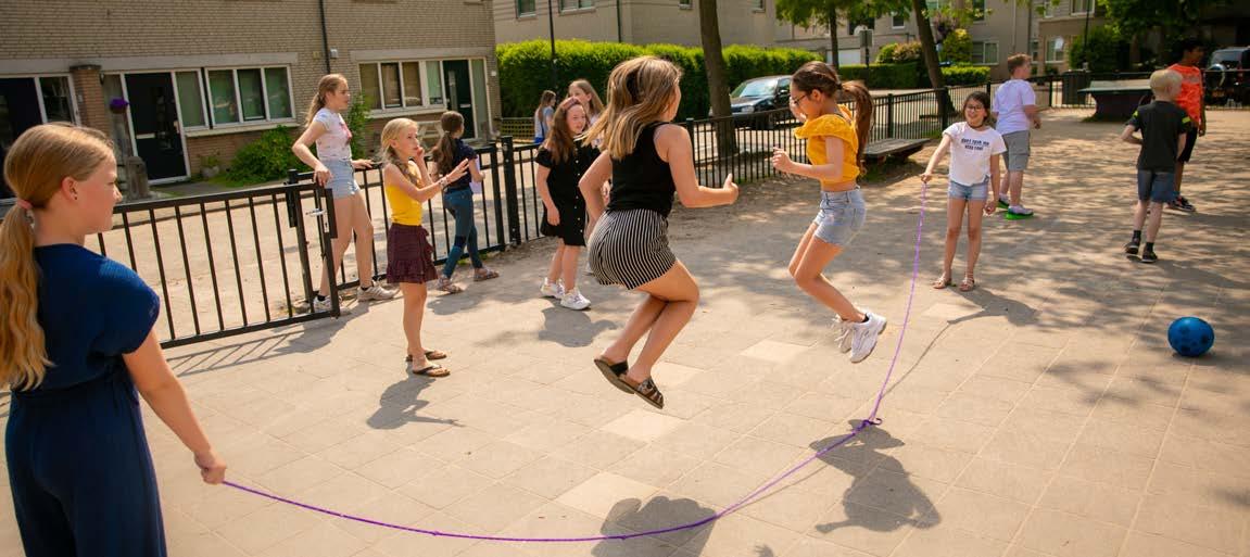 Kinderen spelen touwtje springen op het schoolplein van PCBO De Wonderboom in Amersfoort.