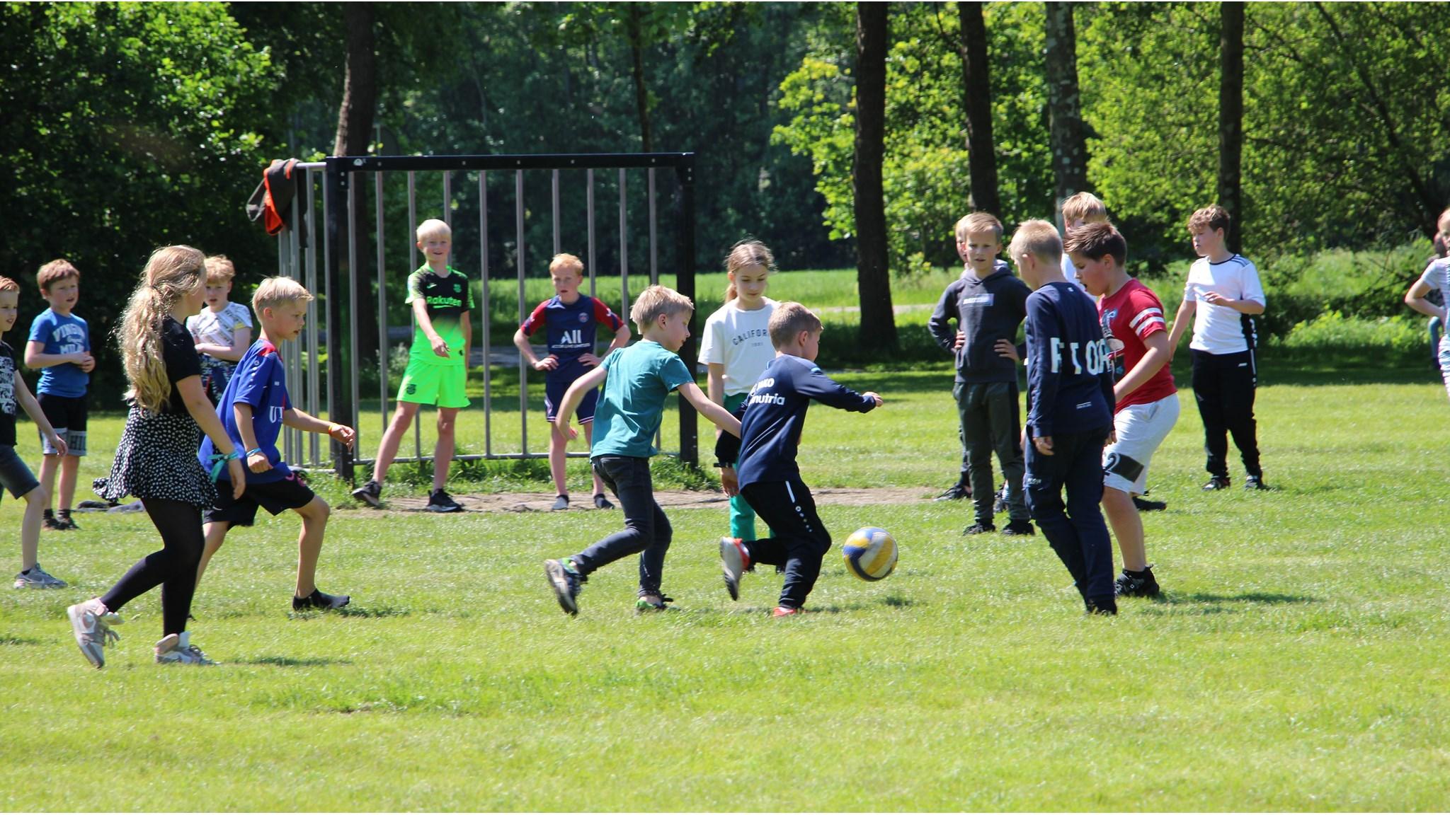 Kinderen spelen voetbal op het schoolplein van de Albertine Agnesschool in Oranjewoud.