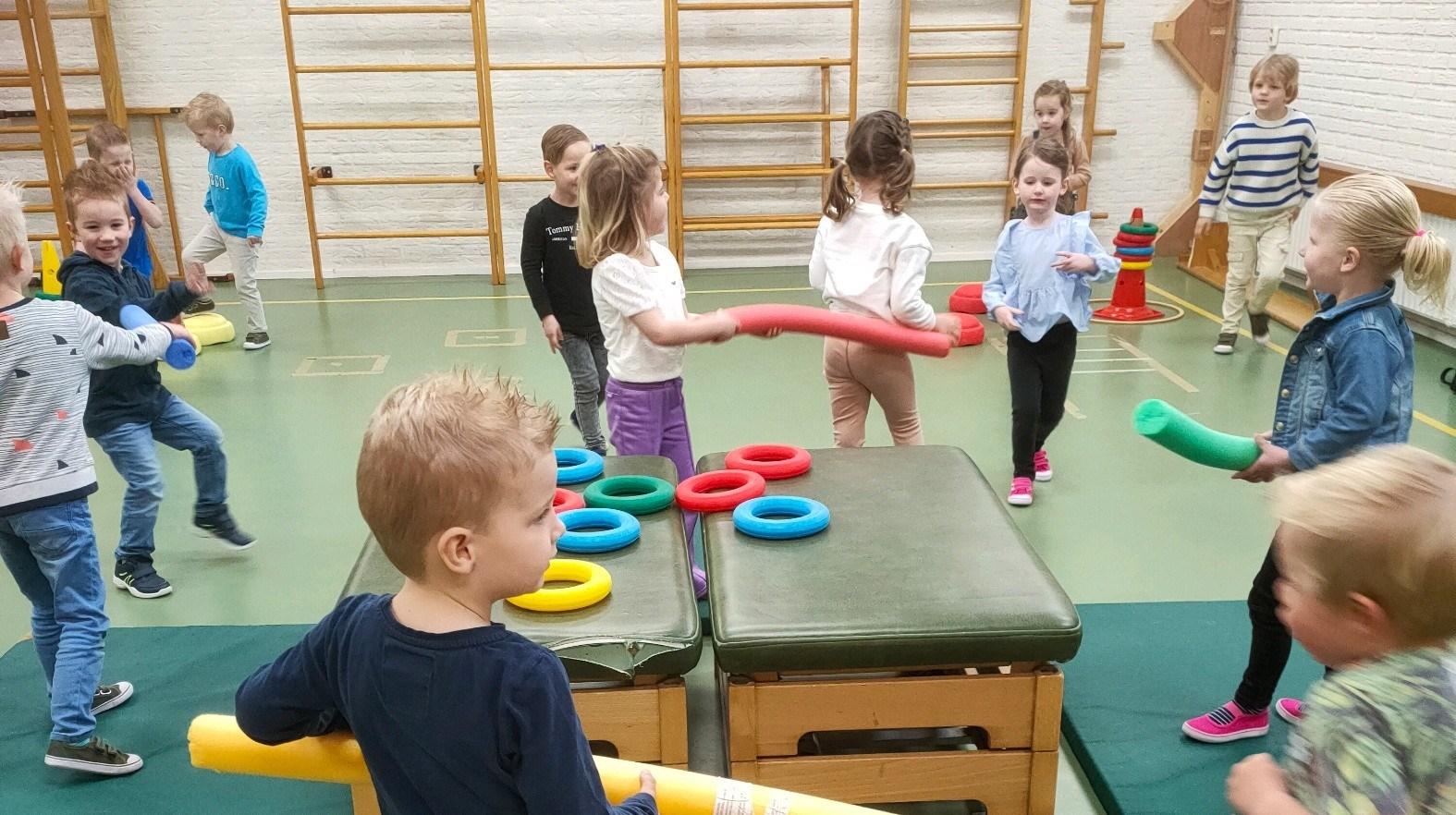 Kinderen spelen vrolijk met kleurrijk speelgoed in de gymzaal van De Morgenster in Wierden. Kinderen spelen vrolijk met kleurrijk speelgoed in de gymzaal van De Morgenster in Wierden.