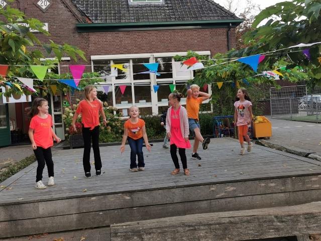Kinderen springen vrolijk op het podium op het schoolplein van Rooms Katholieke Basisschool Sint Martinus in Voorst. Kinderen springen vrolijk op het podium op het schoolplein van Rooms Katholieke Basisschool Sint Martinus in Voorst.