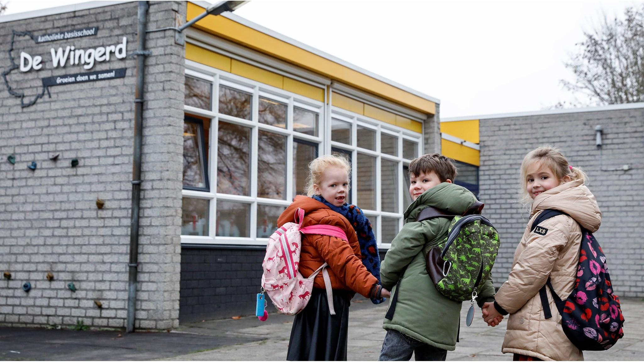 Kinderen staan hand in hand voor de ingang van Basisschool De Wingerd in Nijverdal. Kinderen staan hand in hand voor de ingang van Basisschool De Wingerd in Nijverdal.