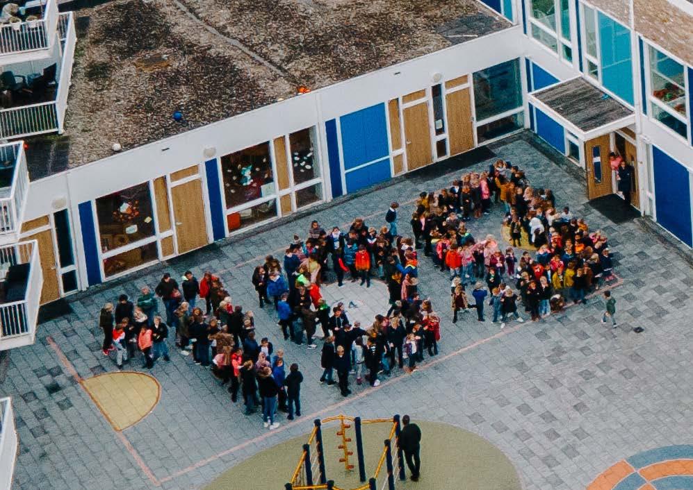 Kinderen staan in een cirkel op het schoolplein van Hannie Schaft Basisschool in Zandvoort. Kinderen staan in een cirkel op het schoolplein van Hannie Schaft Basisschool in Zandvoort.