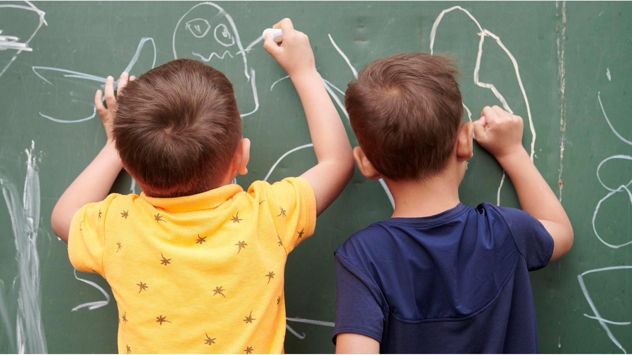 Kinderen tekenen met krijt op een schoolbord op Openbare Basisschool De Wilgenhoek in Haarlem.