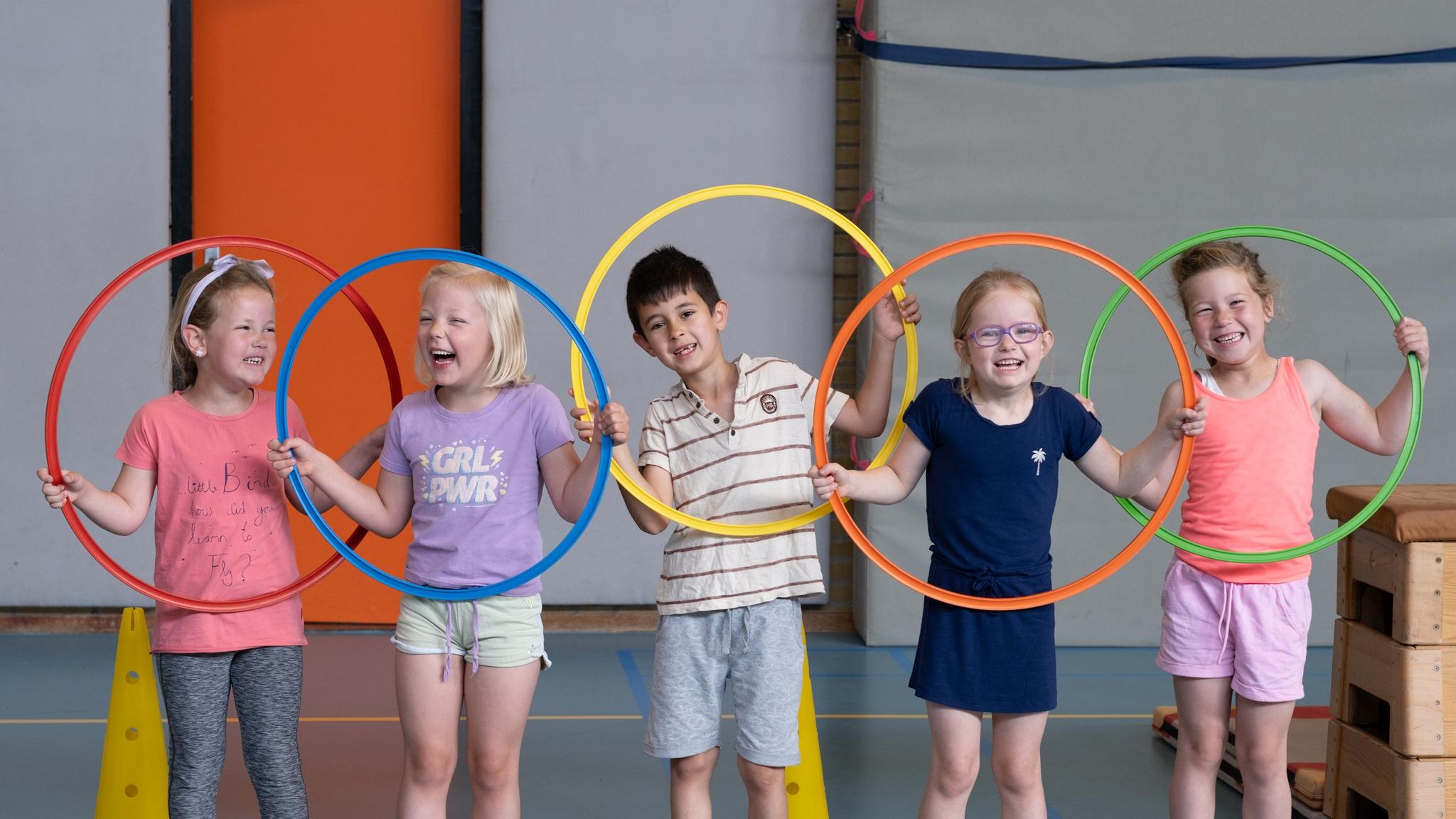 Kinderen van Basisschool Bonifatius in Enschede spelen vrolijk met hoepels in de gymzaal. Kinderen van Basisschool Bonifatius in Enschede spelen vrolijk met hoepels in de gymzaal.