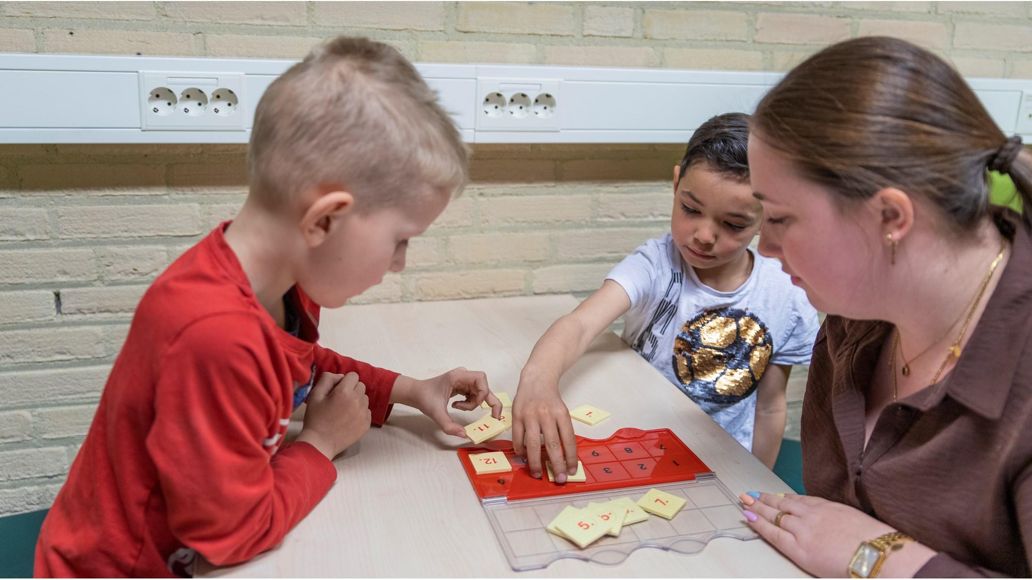 Kinderen van Basisschool De Schakel in Kerkrade spelen een educatief spelletje samen met een juf. Kinderen van Basisschool De Schakel in Kerkrade spelen een educatief spelletje samen met een juf.