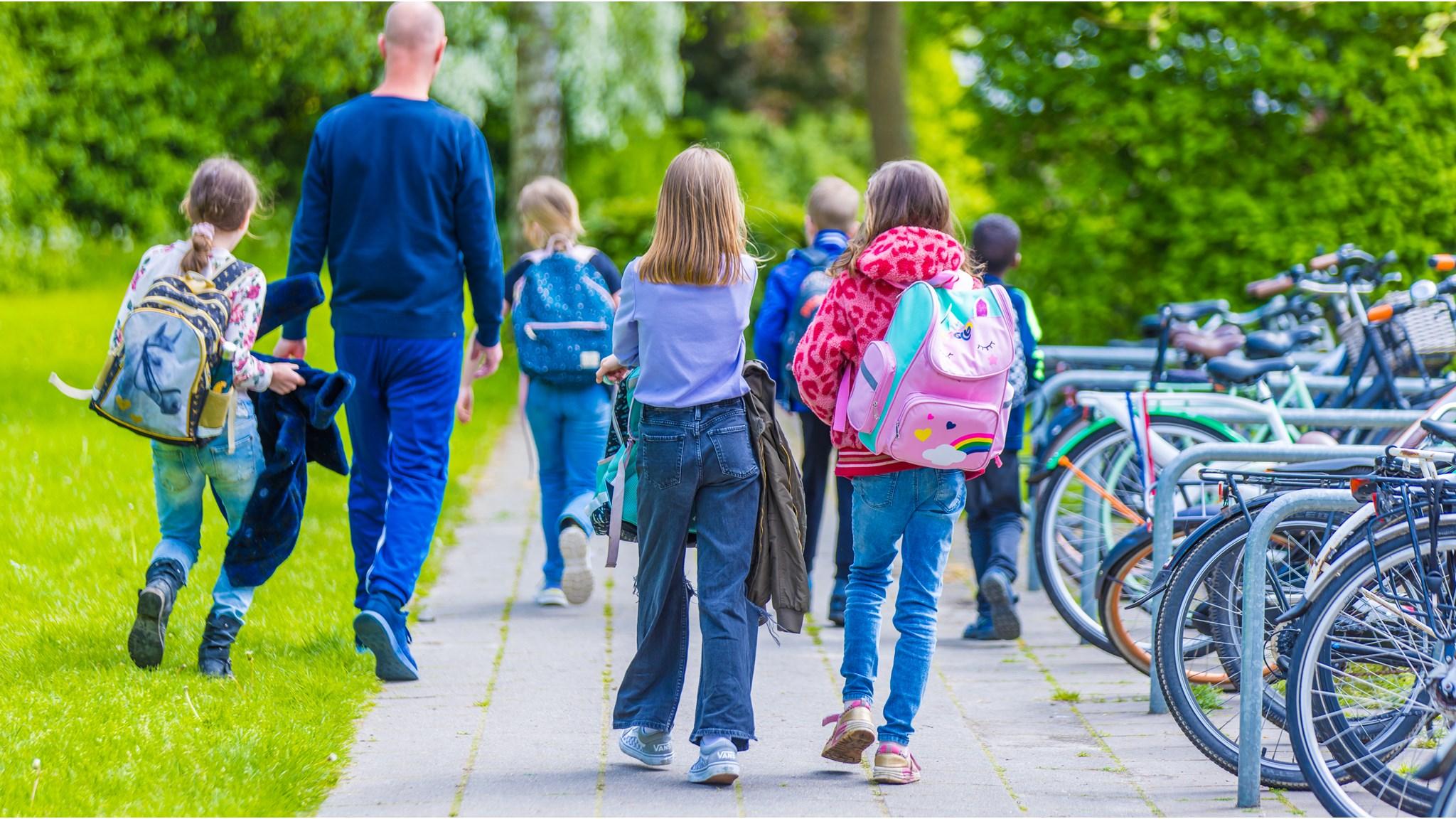 Kinderen van Basisschool De Triangel in Grijpskerk lopen naar het schoolplein na schooltijd.