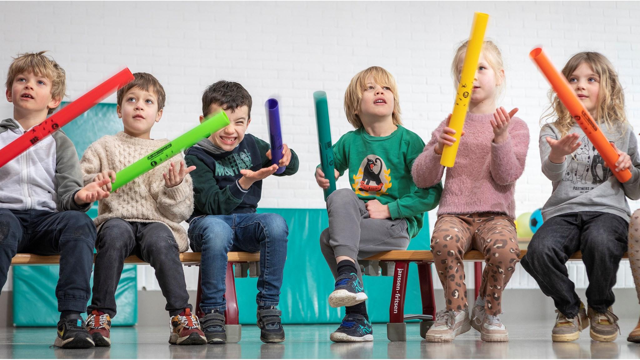 Kinderen van basisschool Jacob Maris in Rotterdam spelen met kleurrijke muzieksticks in de klas. Kinderen van basisschool Jacob Maris in Rotterdam spelen met kleurrijke muzieksticks in de klas.