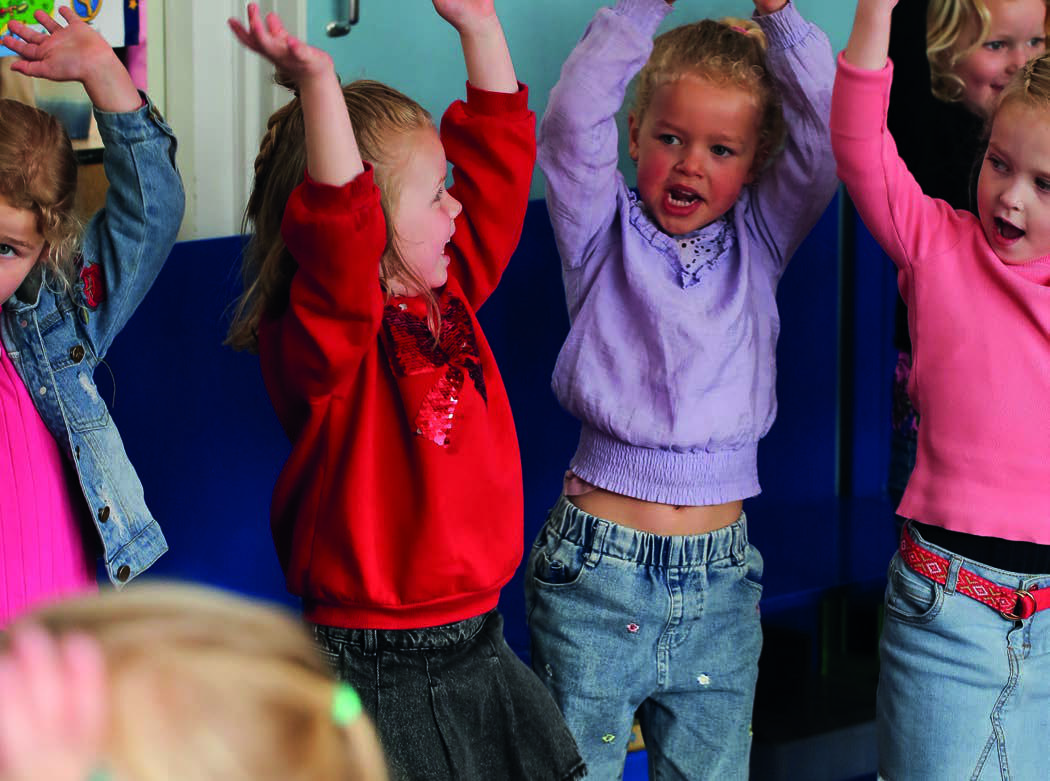 Kinderen van Christelijk Kindcentrum Ichthus in Genemuiden vieren een vrolijk moment met opgestoken handen. Kinderen van Christelijk Kindcentrum Ichthus in Genemuiden vieren een vrolijk moment met opgestoken handen.