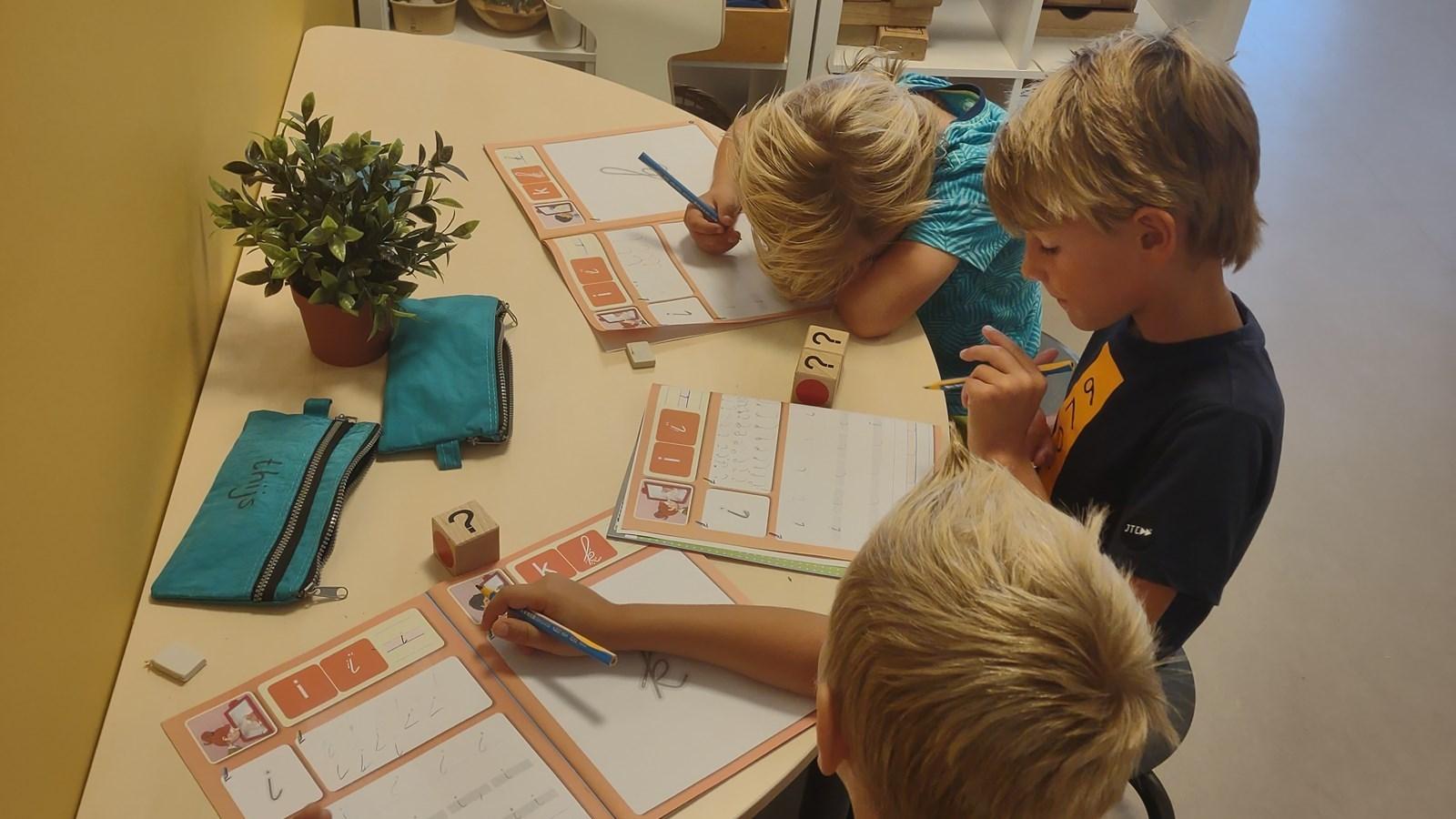 Kinderen van de Jozefschool Texel in Den Burg zijn bezig met schrijfopdrachten aan een tafel. Kinderen van de Jozefschool Texel in Den Burg zijn bezig met schrijfopdrachten aan een tafel.