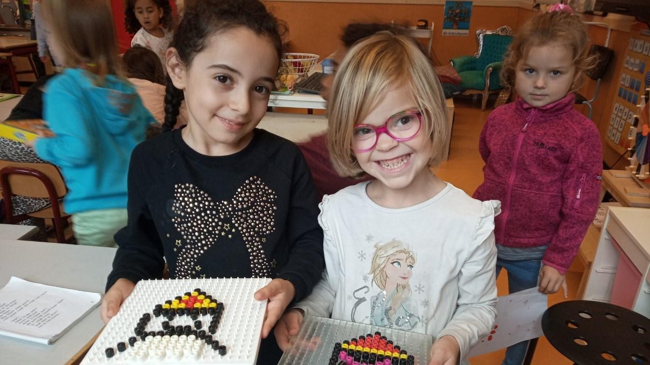 Kinderen van De Meander in Lelystad poseren trots met hun creatieve zelfgemaakte kunstwerken.