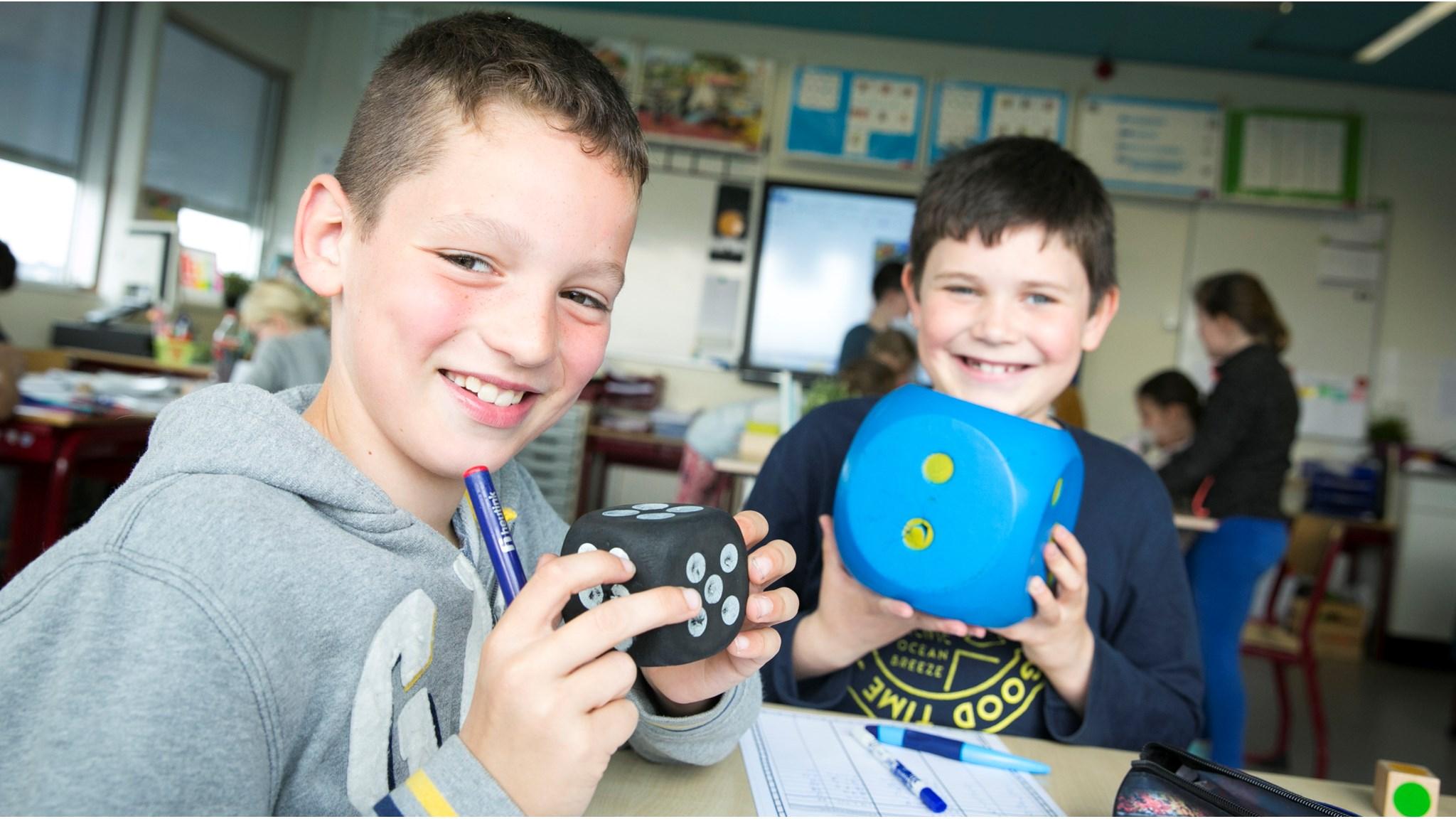 Kinderen van de P.C. Jenaplanschool Zonnewereld in Vleuten spelen met vrolijke dobbelstenen in de klas. Kinderen van de P.C. Jenaplanschool Zonnewereld in Vleuten spelen met vrolijke dobbelstenen in de klas.