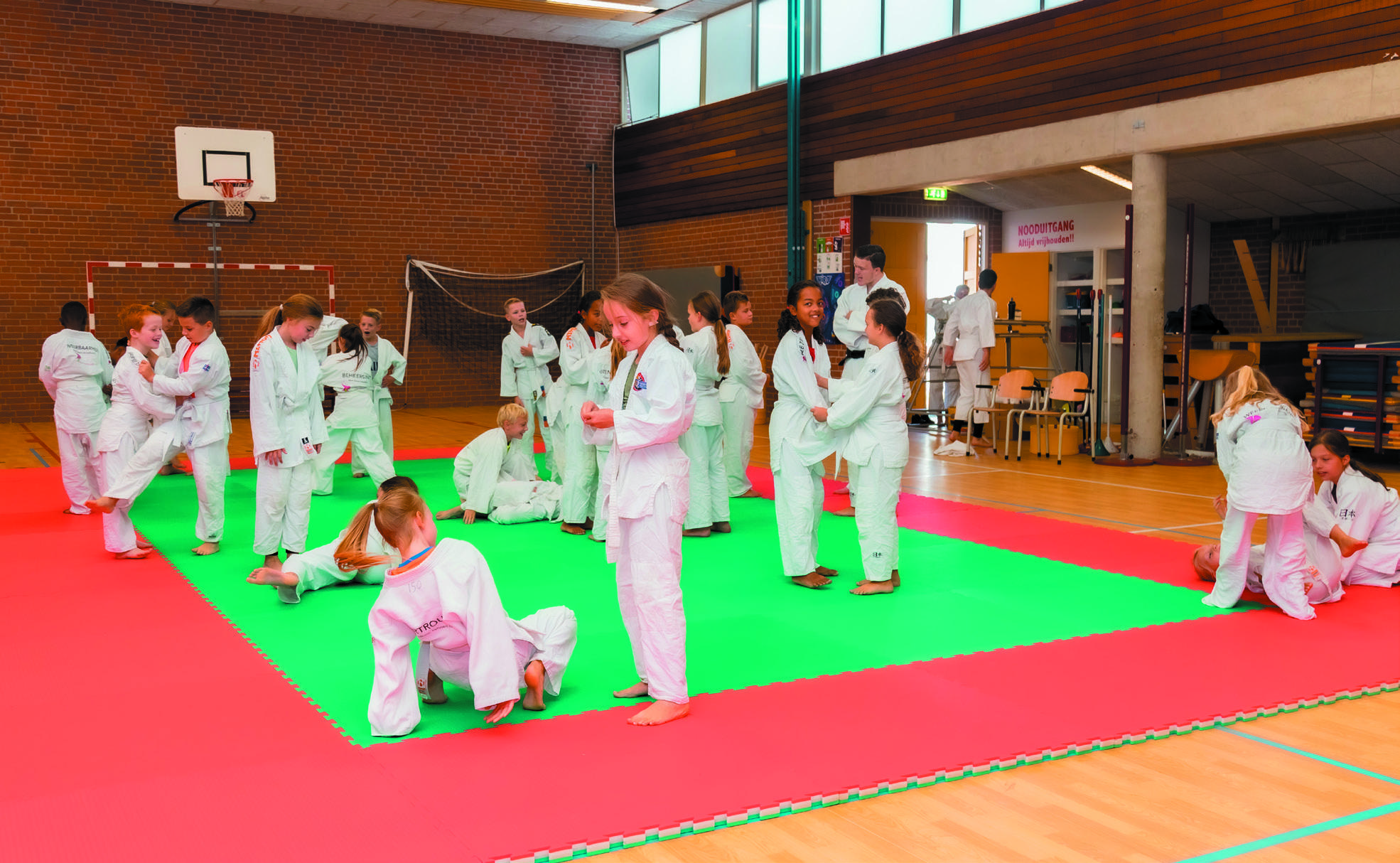 Kinderen van De Trompetvogel in Nieuwegein oefenen judo op een speciaal ingerichte mat in de gymzaal. Kinderen van De Trompetvogel in Nieuwegein oefenen judo op een speciaal ingerichte mat in de gymzaal.