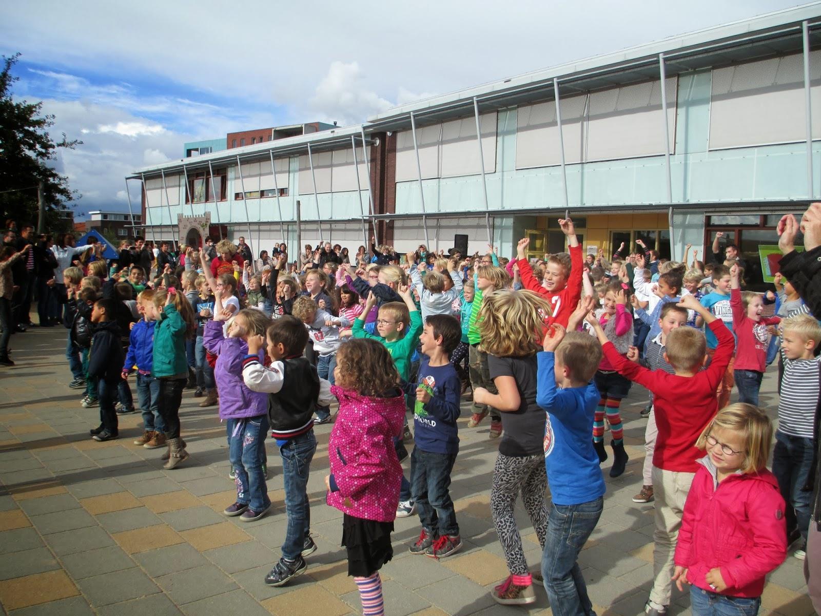 Kinderen van De Wegwijzer in Elst (Gelderland) vieren een activiteit op het schoolplein. Kinderen van De Wegwijzer in Elst (Gelderland) vieren een activiteit op het schoolplein.