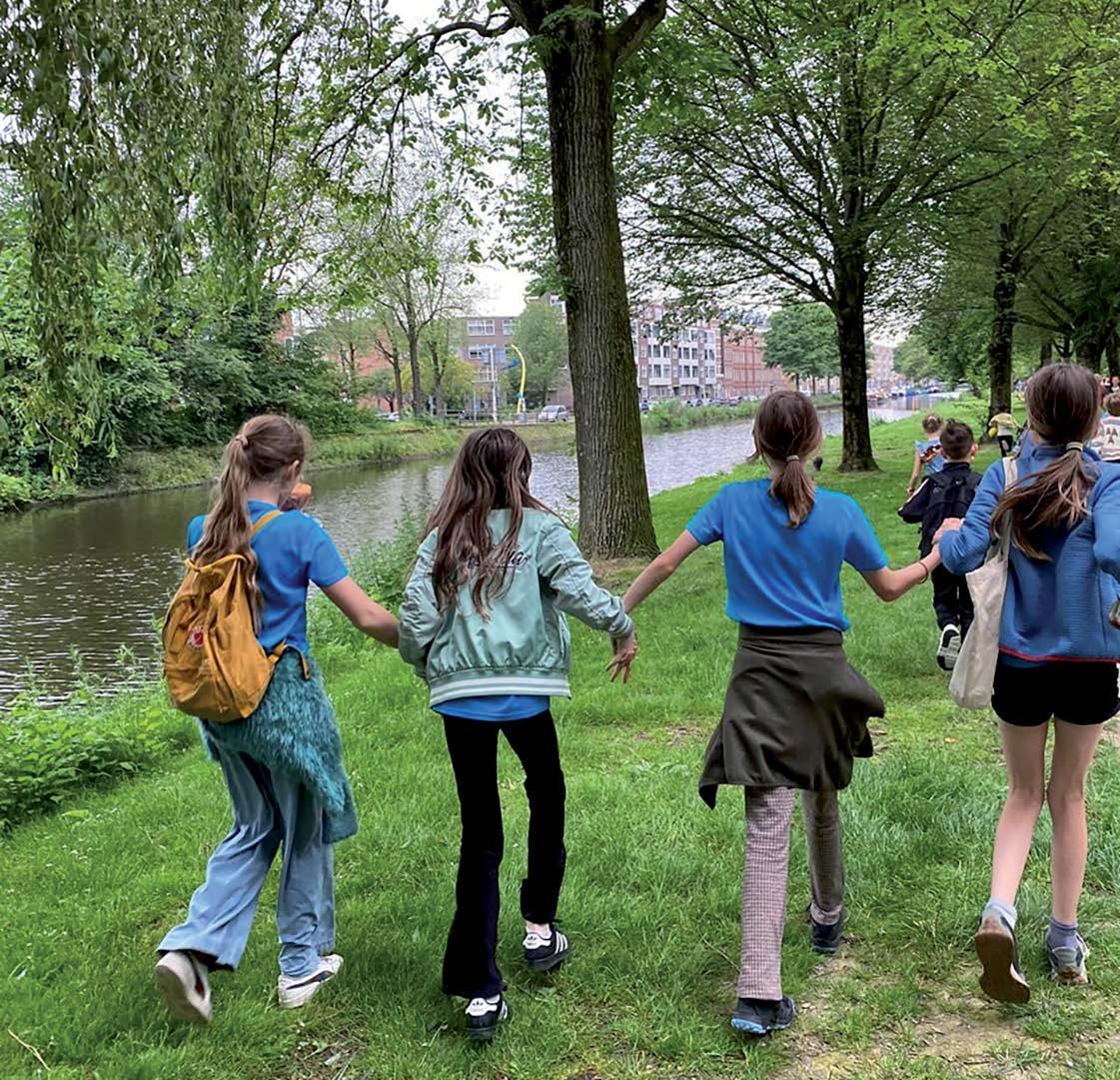 Kinderen van De Wegwijzer in Lomm wandelen hand in hand langs het water. Kinderen van De Wegwijzer in Lomm wandelen hand in hand langs het water.