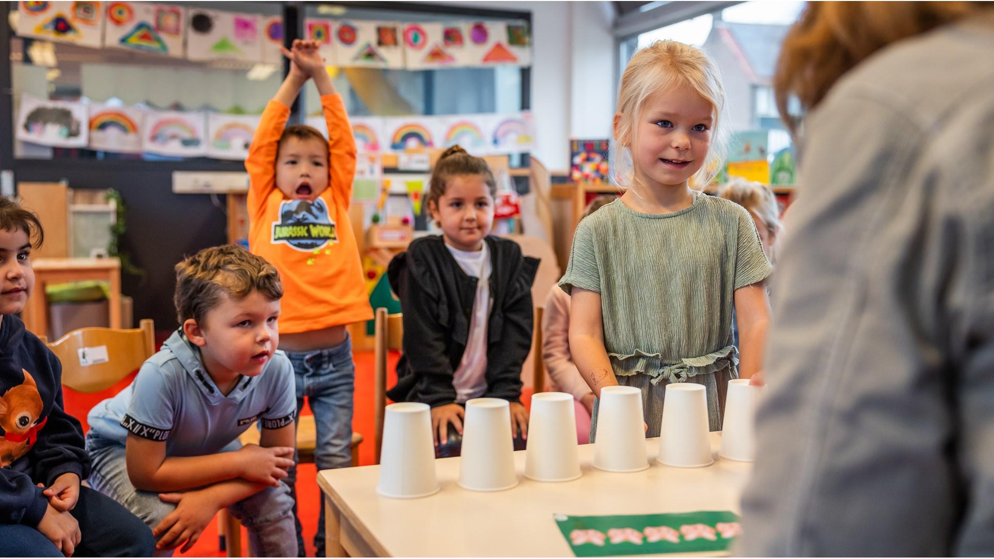 Kinderen van De Zonnewijzer in Bussum kijken enthousiast naar een spel met bekers. Kinderen van De Zonnewijzer in Bussum kijken enthousiast naar een spel met bekers.