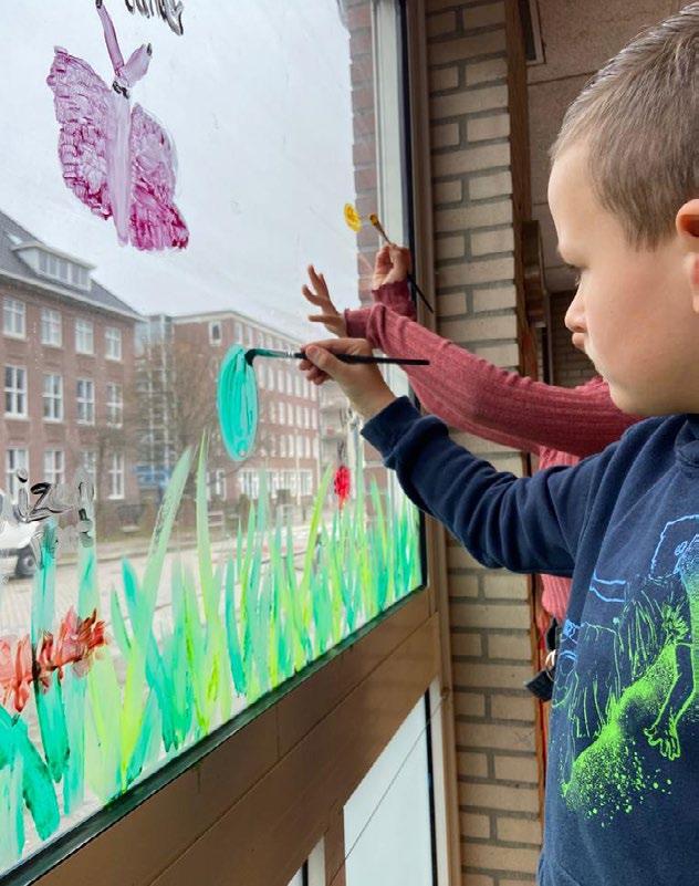 Kinderen van Fellenoord in Eindhoven schilderen kleurrijke bloemen op het raam. Kinderen van Fellenoord in Eindhoven schilderen kleurrijke bloemen op het raam.