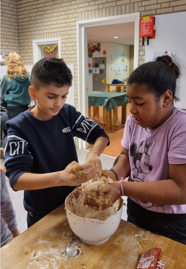 Kinderen van Fellenoord in Eindhoven zijn bezig met het maken van deeg in de klas. Kinderen van Fellenoord in Eindhoven zijn bezig met het maken van deeg in de klas.