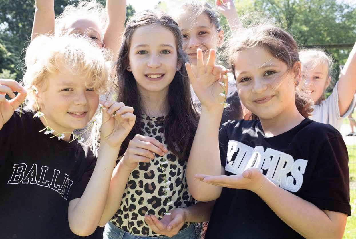 Kinderen van Het Mozaïek in Houten vieren een zonnige dag op het schoolplein met bloemen. Kinderen van Het Mozaïek in Houten vieren een zonnige dag op het schoolplein met bloemen.
